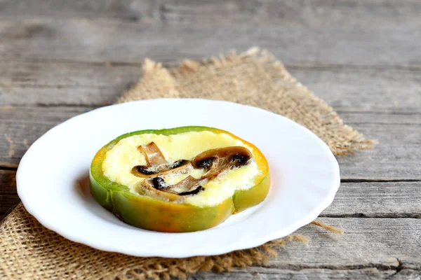 Omelete recheado caseiro em uma chapa e na velha mesa de madeira. Omelete delicioso com cogumelos fritos em um pimentão de sino. Receita de ovo saudável para o café da manhã. Fechar. — Fotografia de Stock