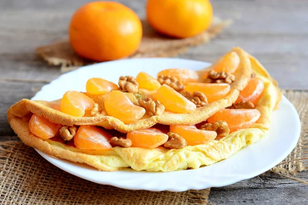 과일 및 견과류와 나무 테이블에 접시에 맛 있는 오믈렛. 튀김 오믈렛 신선한 mandarines과 호두와 박제. 건강 한 채식 음식입니다. 아침 식사 계란 제조 법입니다. 빈티지 스타일입니다. 근접 촬영 — 스톡 사진