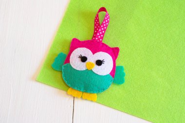 Cute vivid owl toy is made of felt. Hanging felt decoration clipart