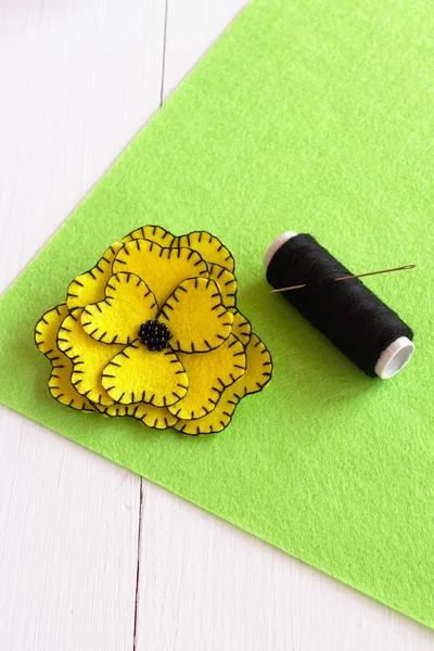 Kit de couture de fleurs en feutre jaune fait à la main sur le feutre vert et fond en bois blanc — Photo