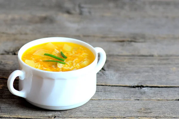 Sopa de arroz. Sopa de arroz casera con carne, papas y zanahorias en un tazón aislado sobre fondo de madera vieja con espacio para copiar el texto. Receta de cena o almuerzo. Primer plano. —  Fotos de Stock