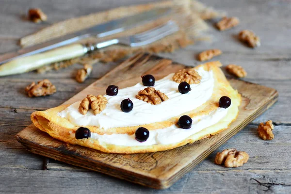 Domácí smažené omelety s tvarohem, ořechy a bobule na dřevěném prkénku. Sladké bobule ranní omeletu. Děti snídaňové menu. Rustikální styl. Closeup — Stock fotografie