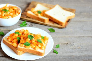 Beyaz ekmek ve plaka sebzeli kuru fasulye. Pişmiş bir kasede beyaz fasulye, dilimleri, maydanoz dal kopya alanı metin için ahşap zemin üzerine ekmek. Sağlıklı bir diyet yemek