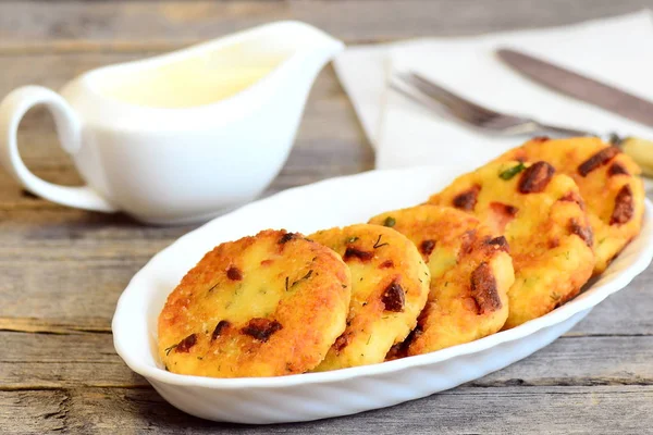 Krispigt stekt couscous färsbiffar med korv och örter på en tallrik, tefat, gaffel och kniv på vintage träbord. Läckra och snabb couscous patties recept. Närbild — Stockfoto