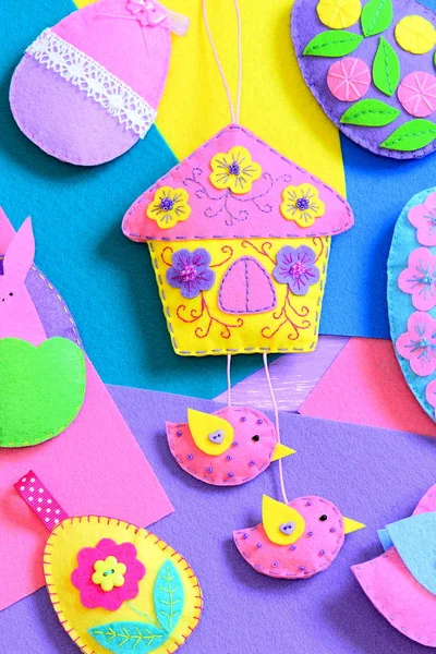 Colourful felt Easter crafts on flat felt sheets. Felt Easter eggs, house with birds, bunny decor. Cute Easter background. Vertical photo. Closeup — Stock Photo, Image
