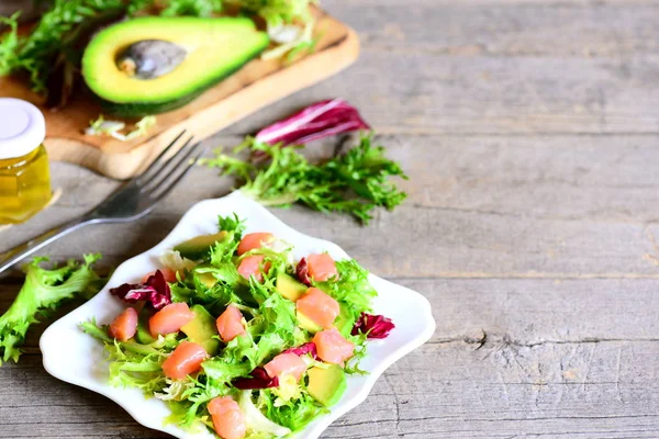 Копченый лосось, салат, салат из авокадо на тарелке. Быстрый и здоровый рецепт салата. Деревянный фон с местом для копирования текста — стоковое фото