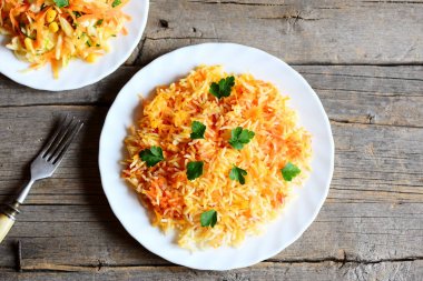 Sağlıklı basmati pirinç sebze ve bir tabak bir tabak, çatal vintage ahşap masa üzerinde lahana salatası maydanoz ile. Vegan öğle veya akşam yemeği tarifi. Üstten Görünüm 