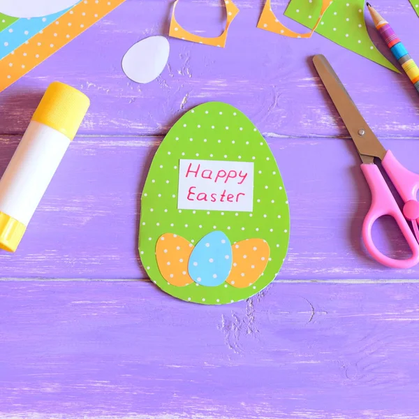 Happy Easter greeting card in egg shape. Easter card made from paper. Materials and tools for children's creativity and development of imagination. Easter paper activities for kids