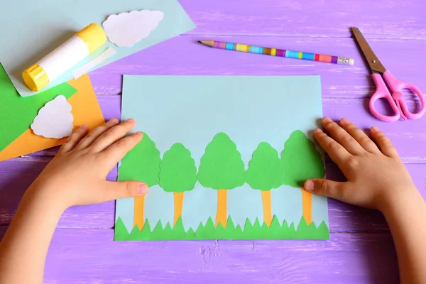 Small child made a Earth day tree card. Materials and tools for create a simple kids crafts. Children hands on a desktop Earth day concept. Earth day paper card idea for kids. Learning activities in kindergarten, at home — Stock Photo, Image