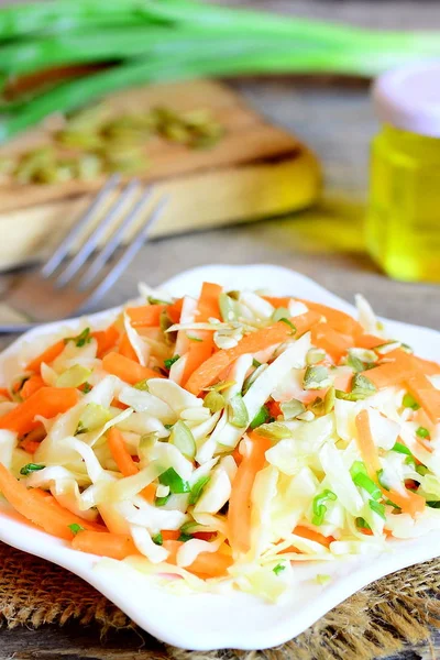 Hausgemachter Krautsalat auf einem Teller. Krautsalat mit Karotten, Kürbiskernen, Gemüse und Zitronensaft und Olivenöl. einfache und schnelle Diät Salat. vertikales Foto — Stockfoto