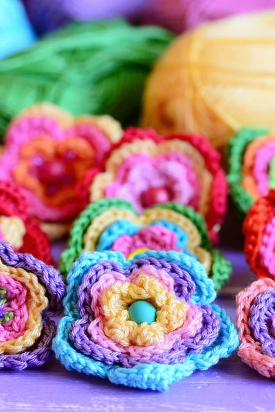 Conjunto de flores multicolores de ganchillo. Crochet motivos de flores y patrones. Interesante hobby para mujeres y niños. Primer plano. Foto vertical — Foto de Stock