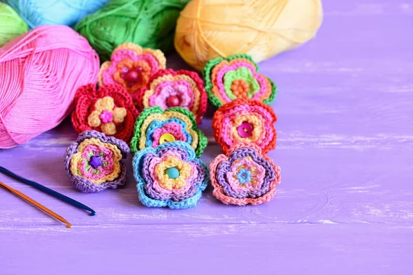 Conjunto de flores de ganchillo colorido. Adornos de flores de ganchillo, hilo de algodón, ganchos sobre un fondo de madera con espacio de copia para texto. Divertida idea de hobby para mujeres y niños. Primer plano. — Foto de Stock