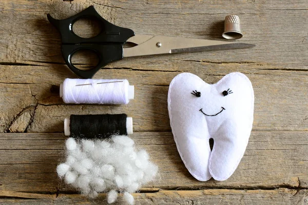Making a felt tooth fairy. Step. Tutorial. Stuffed felt tooth fairy toy, scissors, thread, thimble, needle, filler on vintage wooden table. Simple and fun sewing crafts for kids. Top view. Closeup — Stock Photo, Image