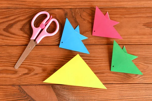 Fogli di carta, forbici su un tavolo di legno marrone. Come fare il pesce origami — Foto Stock