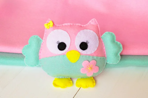 Felt owl on a white wooden background, rolls of pink and blue felt — Stock Photo, Image