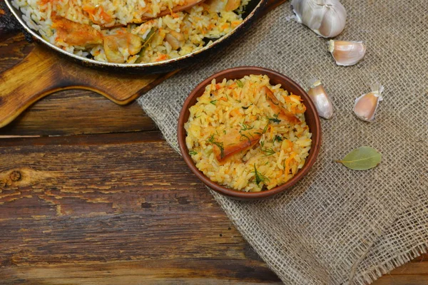 Vintage-Tonschale mit traditionellen würzigen Speisen Pilaf, Pfanne mit Pilaf auf Holzhintergrund und die Klette. Pilaf mit Fleisch — Stockfoto