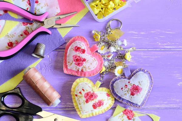 Decorative hearts keychain. Handmade felt and fabric keychain on bag or backpack. Summer accessory for women or girls. Crafts and craft supplies background. Top view — Stock Photo, Image