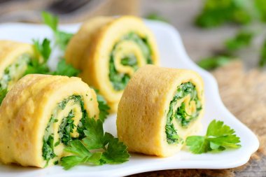 Peynir ve otlar doldurulmuş omlet. Rendelenmiş peyniri ve ince kıyılmış otlar ile doldurulmuş omlet kesti. Lezzetli ve sağlıklı bir kahvaltı fikir. Rustik tarzı. Portre