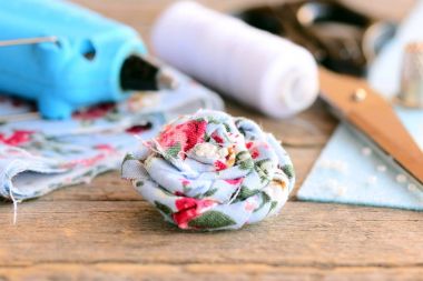 Güzel çiçek broş. Kumaş Tekstil Eko Dostu Broş dekore edilmiş boncuklar, sıcak tutkal tabancası, makas, iş parçacığı biriktirme, yüksük, eski ahşap masa hissettim. Yaz Çiçek Broş el sanatları. Zanaat kavramı