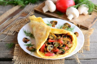 Doldurulmuş omlet fikir. Domates ve dereotu bir tabak, çatal, bıçak, taze mantar, domates, dereotu vintage ahşap zemin üzerinde mantar omlet. Hızlı ve kolay vejetaryen omlet. Rustik tarzı