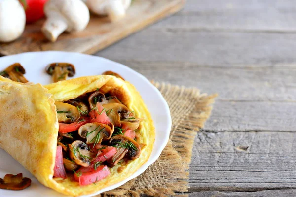 Gefülltes Eieromelett. Champignons-Omelett mit Tomaten und Dill auf einem Teller und auf einem hölzernen Hintergrund mit Kopierplatz für Text. schnelle und einfache Frühstück Omelette. rustikaler Stil — Stockfoto