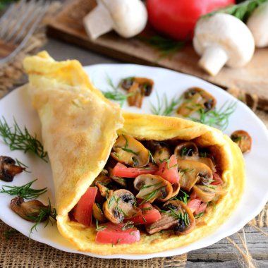 Vejetaryen omlet fikir. Kızarmış domates ve dereotu bir plaka üzerinde omlet mantar. Taze mantar, domates, dereotu vintage ahşap arka plan üzerinde. Kolay yumurta omlet. Rustik tarzı. Sağlıklı gıda