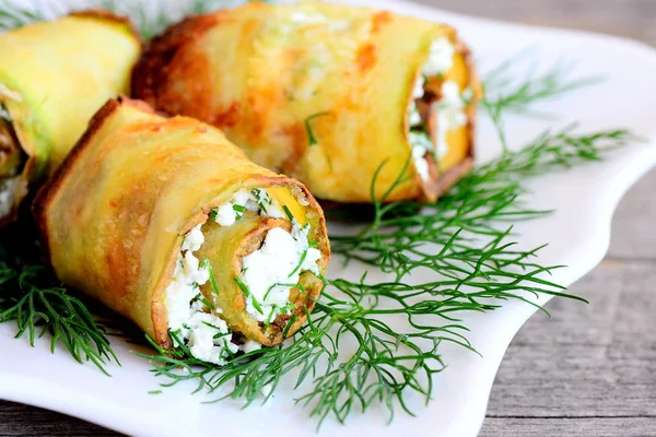 Cheese zucchini rolls. Roasted zucchini rolls stuffed with cottage cheese and herbs on a plate. Festive vegetarian appetizer recipe. Closeup — Stock Photo, Image