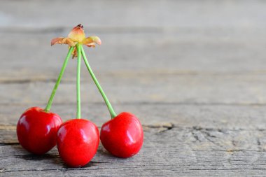 Üç parlak tatlı bir vintage ahşap arka plan metin için boş bir alan ile izole kiraz