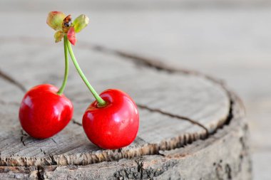 Eski ahşap arka plan metin yazabileceğiniz boş bir kopya ile izole iki ham tatlı kiraz 