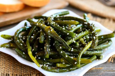 Kızarmış sarımsak okları meze. Baharatlı yeşil sarımsak baharat ve susam bir plaka üzerinde oklarla. Kolay, ucuz ve sağlıklı tarifi fikir. Portre