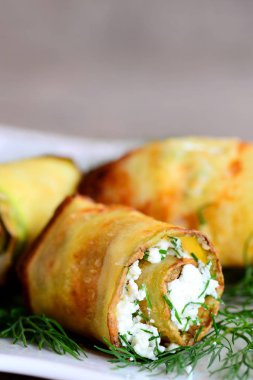 Rulo şeritler kabak yapılan ve süzme peynir ve dereotu ile doldurulmuş. Kızarmış kabak bir plaka üzerine dereotu ile süslenmiş alır. Ev güzel meze tarifi. Dikey fotoğraf