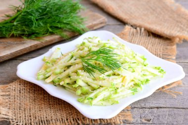 Kabak salatası peynir ile şerit. Taze kabak, peynir ve bir plaka üzerinde kıyılmış dereotu ile sağlıklı salata. Basit ve hızlı yaz salatası. Rustik tarzı. Portre