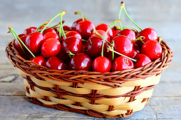 Cherry Red sweet w kosz Wiklinowy brązowy i na vintage drewnianym stole. Letni sweet cherry sezon koncepcja. Zbliżenie — Zdjęcie stockowe