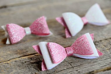 Güzel güzel saçlar için yay. Pembe ve beyaz parlak yay kızları için hissettim. Güzel saç aksesuarları üzerinde ahşap bir masa ayarla 