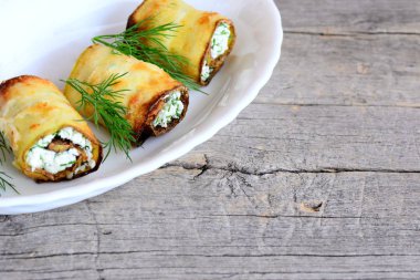 Sebze süzme peynir dolum alır. Kızarmış kabak süzme peynir ve dereotu ile doldurulmuş bir beyaz plaka ve vintage ahşap arka plan kopya alanı için metin ile rulo