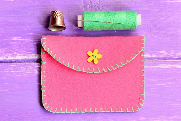 How to make a simple felt purse. Step. Sewing crafts tutorial. Handmade pink felt purse, thread, thimble on a wooden table. Top view — Stock Photo, Image