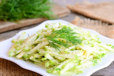 Çiğ kabak ve peynir salatası limon salata sosu ile. Çiğ kabak, peynir, susam ve beyaz tabakta dereotu ile hafif salata. Hızlı ve lezzetli vejetaryen salata. Rustik tarzı. Portre