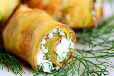 Sebze süzme peynir ile bir plaka üzerinde rulo. Ev yapımı kızarmış kabak dolması süzme peynir ve ince kıyılmış dereotu ile alır. Portre