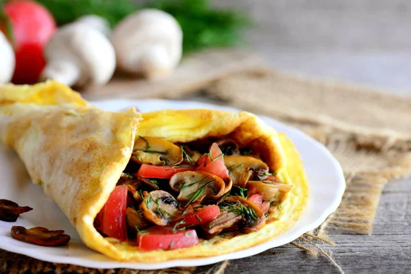 Pilz-Tomaten-Omelett auf einem Teller. Eieromelette gefüllt mit Pilzen, Tomaten und Dill. leichte Mittag- oder Abendessen Idee. Landhausstil — Stockfoto