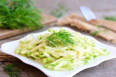 Peynirli kabak kabak salatası. Çiğ kabak kabak dilimleri, peynir dilimleri ve bir plaka üzerinde kıyılmış dereotu ile ev yapımı salata. Basit ve lezzetli sebze yaz salatası. Rustik tarzı. Portre