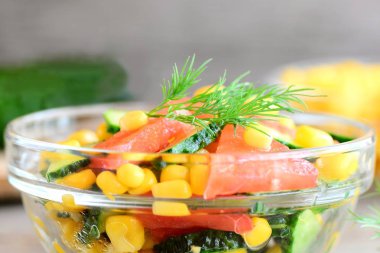 Bir cam kase taze sebze salatası. Salata taze salatalık, domates, Mısır, zeytinyağı ve limon sosu ile. Portre