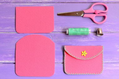 Çocuk sarı çiçek ahşap düğme ile Keçe Çanta pembe. Makas, Tel, iğne, ahşap bir masa üzerinde yüksük. Kolay ev yapımı DIY keçe ile yapılmış. Üstten Görünüm