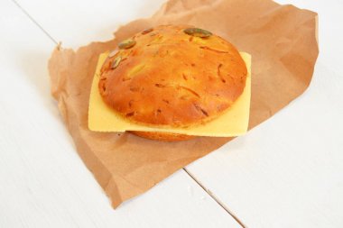 Bir dilim peynir kağıt ve beyaz tahta arka plan ile sandviç 