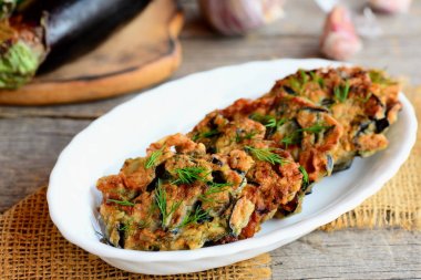 Közlenmiş Patlıcan pirzola. Kızarmış patlıcan sarımsak ve beyaz bir tabak ve vintage bir ahşap masa dereotu ile börek. Yaratıcı vejetaryen patlıcan tarifi. Portre