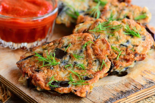 Chuletas de berenjena rápidas y fáciles. Chuletas de berenjena frita con ajo y eneldo en una tabla de madera. Salsa de tomate en un tazón de vidrio. Receta vegetariana saludable. Primer plano. — Foto de Stock