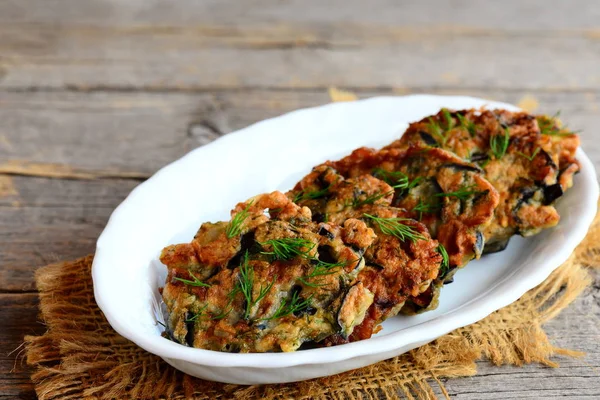 Costeletas de berinjela fritas com alho e endro em uma placa branca e um fundo de madeira vintage. Deliciosa receita vegetariana de verão. Fechar. — Fotografia de Stock