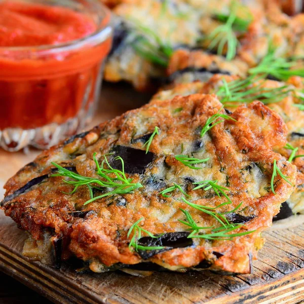 Chuletas simples de berenjena frita con ajo y eneldo en un plato blanco y una mesa de madera vintage. Salsa de ketchup de tomate en un tazón de cristal. Vegetales chuletas de berenjena idea. Primer plano. — Foto de Stock