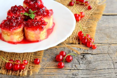 Tatlı çilek reçeli ile krep. Parlak Frenk üzümü reçeli ve nane yaprağı beyaz bir tabak ve eski bir ahşap masa ile krep. Güzel yaz kahvaltı. Rustik tarzı