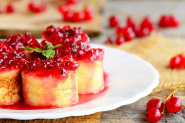 Frenk üzümü sos ile doldurulmuş krep. Krep suşi beyaz bir tabak ve vintage ahşap bir masa. Çocuklar ve tüm aile için sağlıklı ve lezzetli kahvaltı