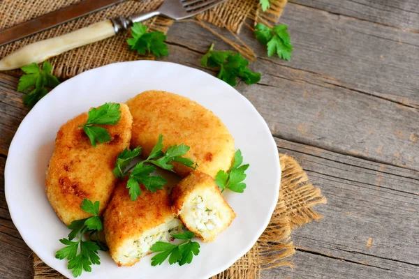 Côtelettes végétariennes maison avec garniture aux œufs sur une assiette blanche. Côtelettes de pommes de terre au chou-fleur rôties avec garniture aux œufs. Recette délicieuse et folle. Vieux fond en bois avec place vide pour le texte. Style rustique — Photo